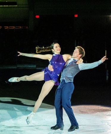 Two ice skaters performing at a skating rink