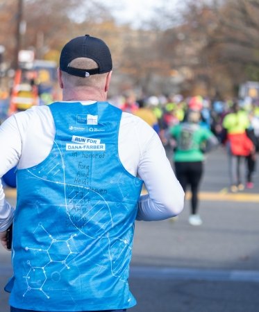 Runner on a race course in a Dana-Farber singlet