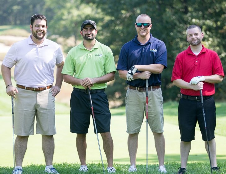 Four golfers on a golf course