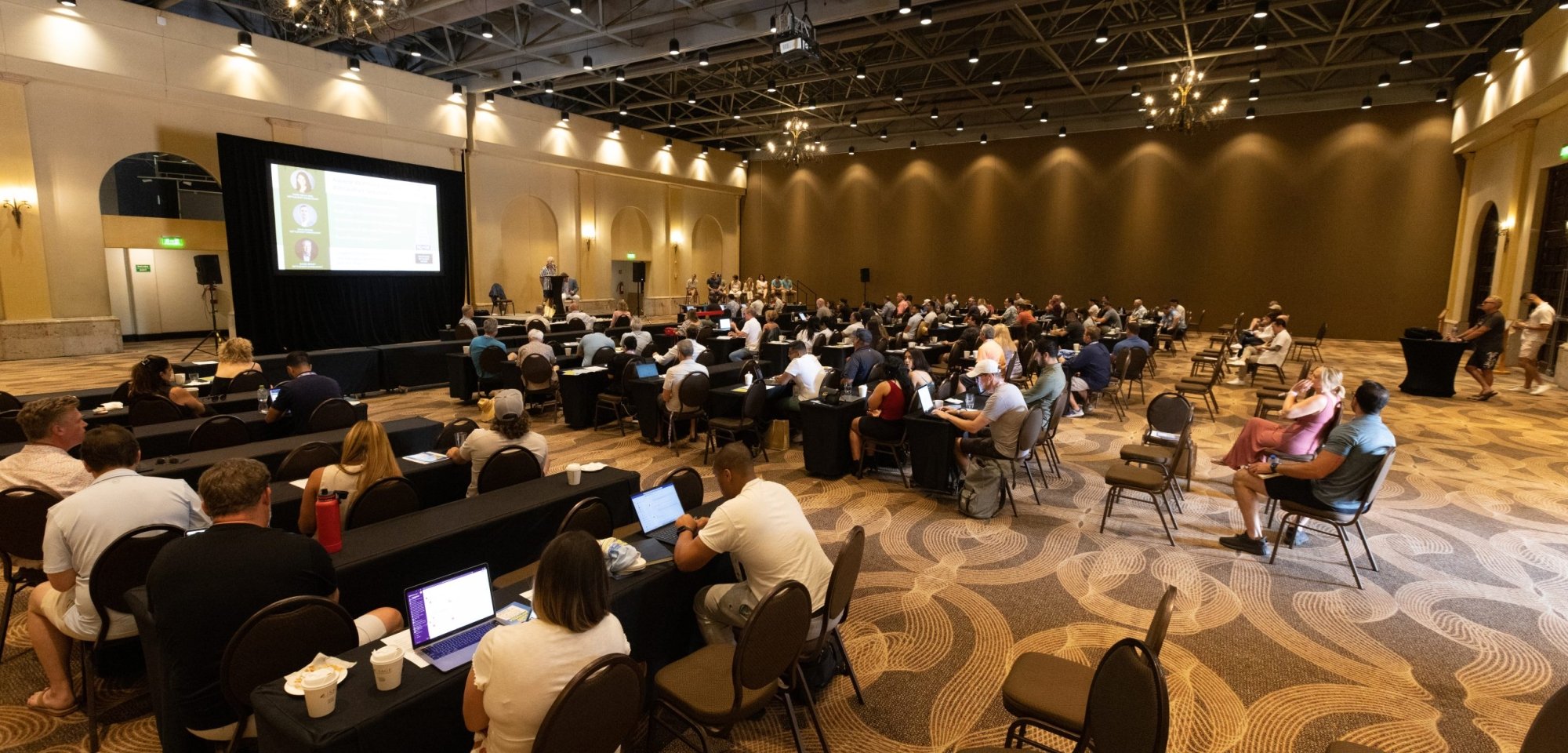 Full room of conference attendees during a presentation