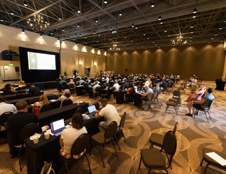 Full room of conference attendees during a presentation