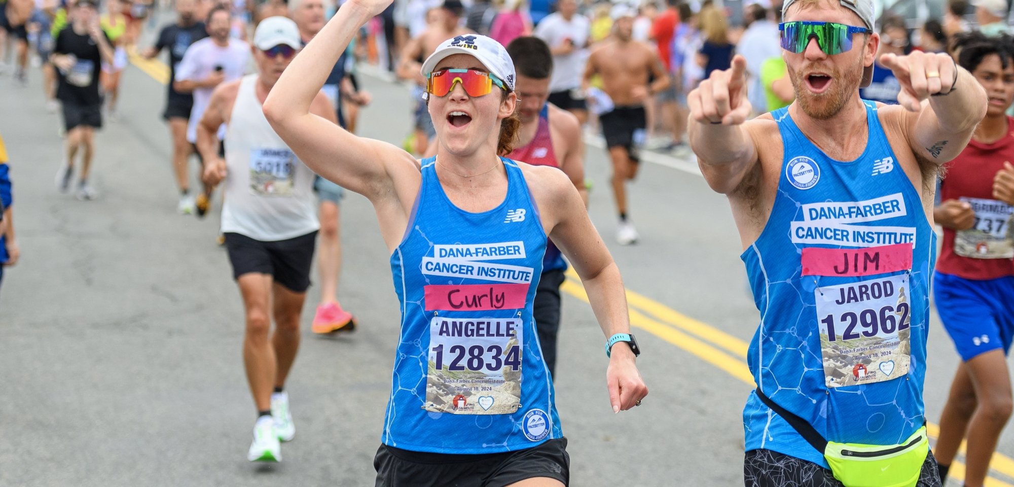 Two runners cheering on the course at the Falmouth Road Race