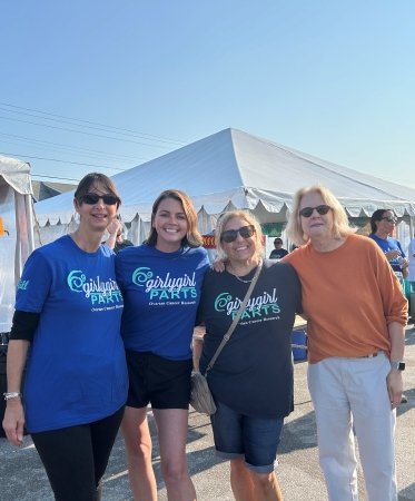 Four people in front of tents in an outdoor market