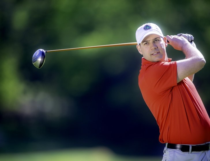 A golfer taking a swing wearing a Jimmy Fund Golf hat