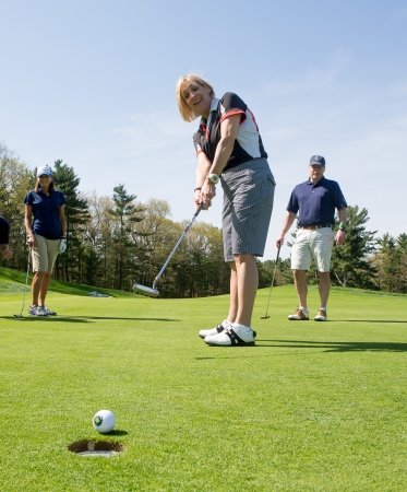 Four golfers playing a round on a course on a sunny day