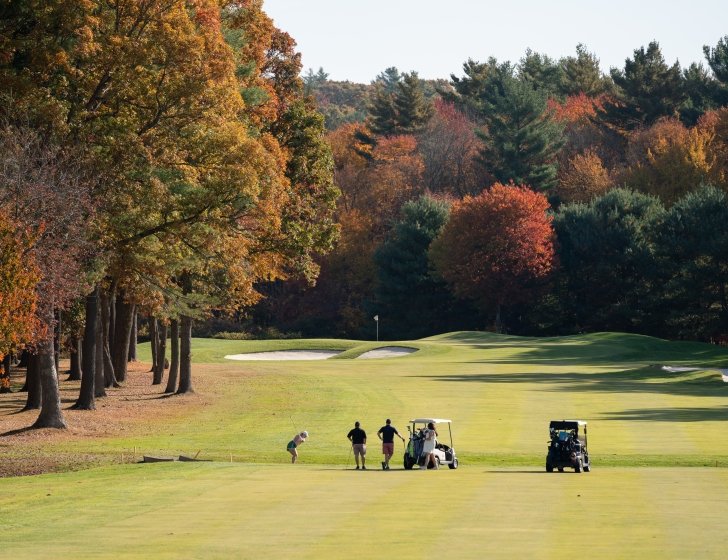 Four golfers on the course on a beautiful fall day