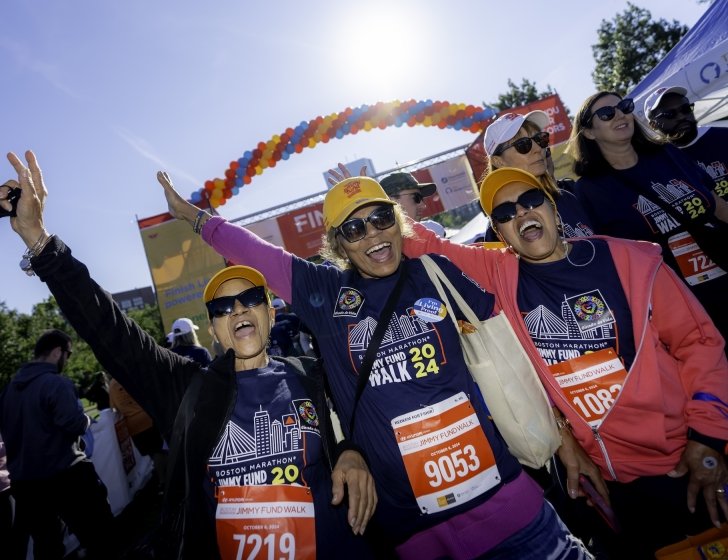 Three Jimmy Fund Walk participants cheering at the finish line