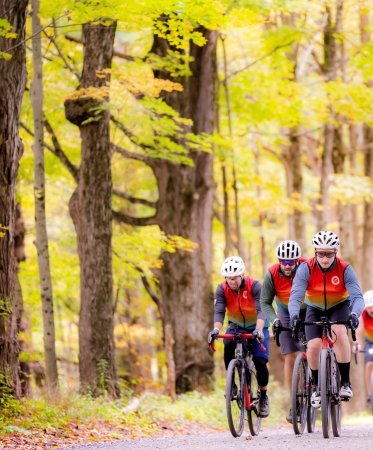 Group of riders biking in the woods with the PMC Unpaved