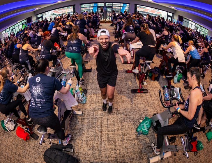A spin instructor cheers on participants at the PMC Winter Cycle at Fenway Park 
