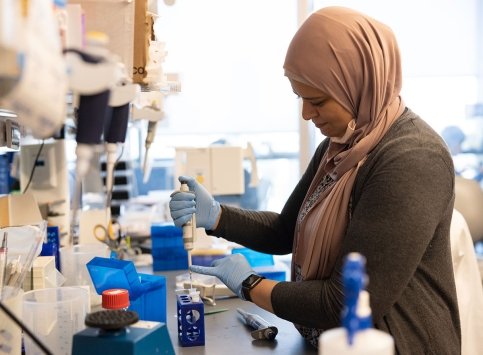 A Dana-Farber staff member conducts an experiment in the lab