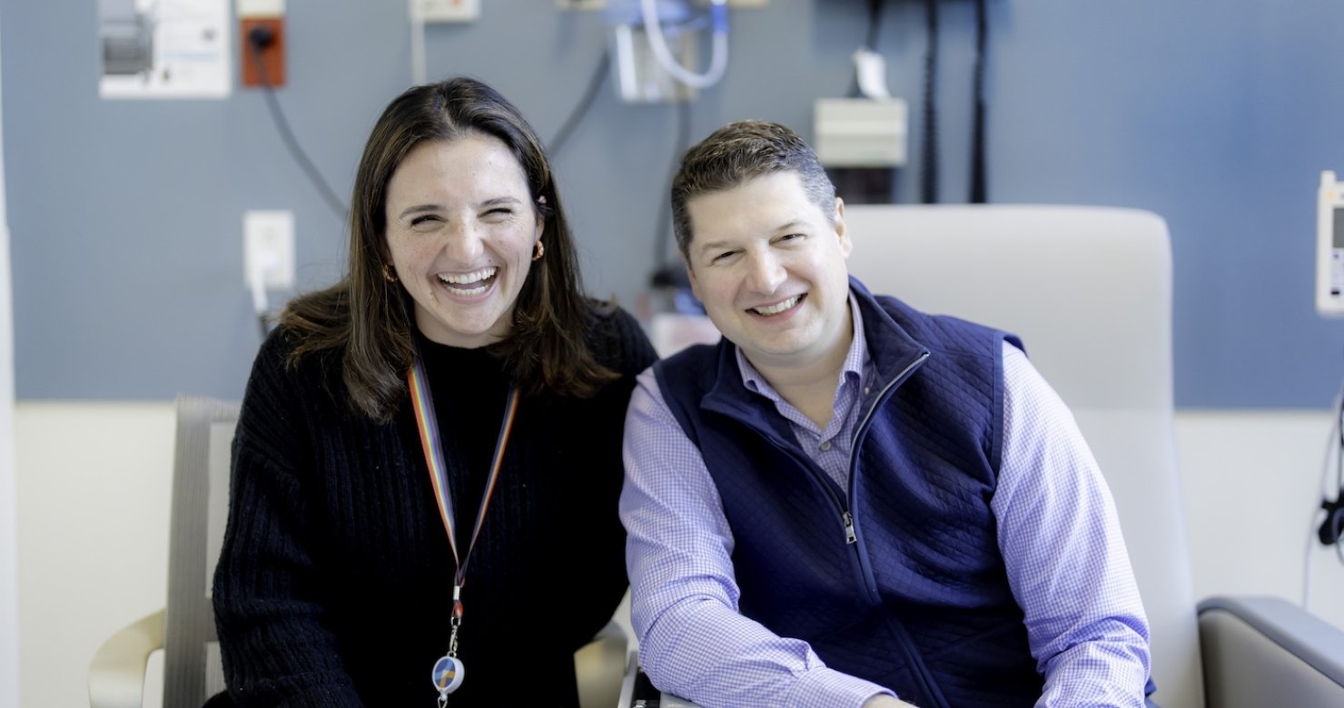 A healthcare provider sits next to an adult patient at Dana-Farber