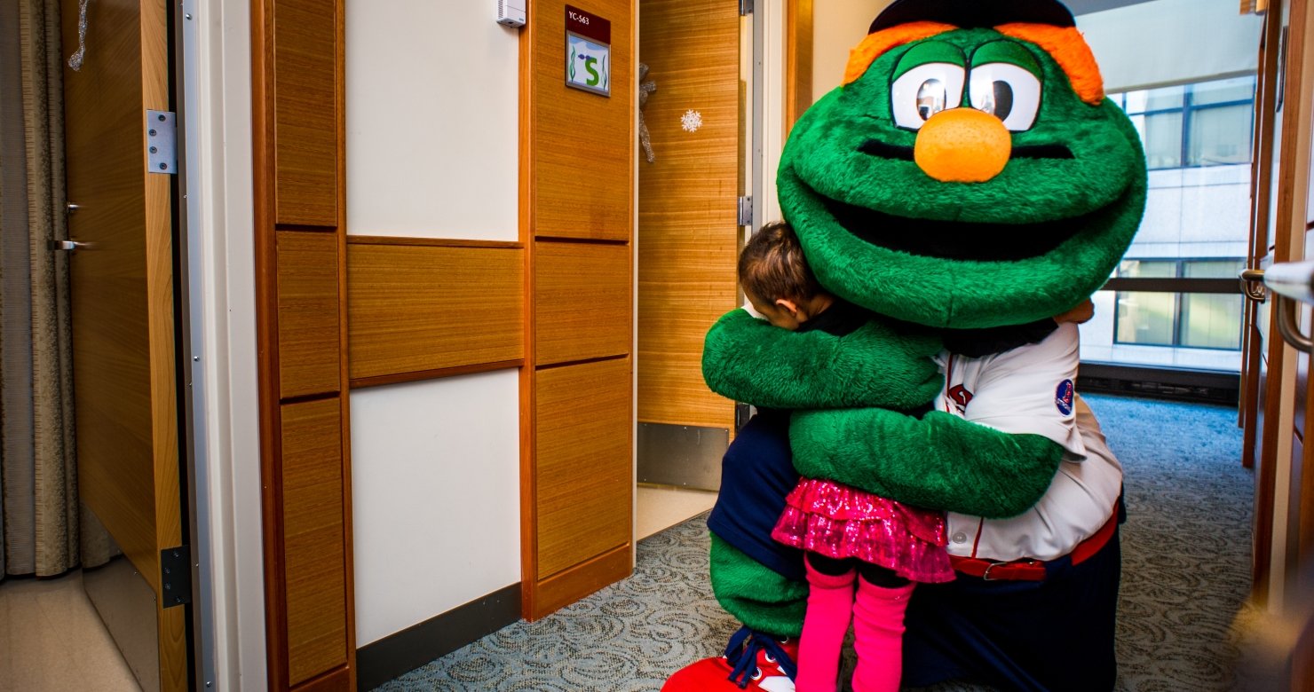Young Dana-Farber patient hugging Red Sox mascot Wally