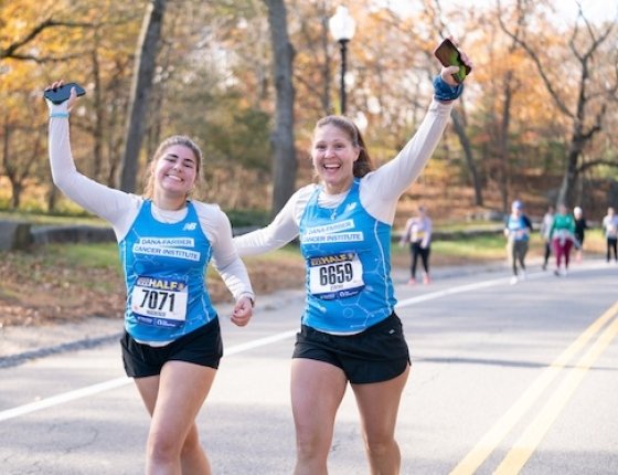 Two runners cheering on the course wearing Run for Dana-Farber singlets