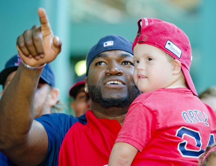 David Ortiz holds a patient in his arms and points into the distance