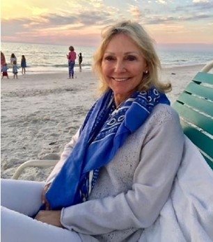 Dawn sitting on a chair on the beach with sunset in background