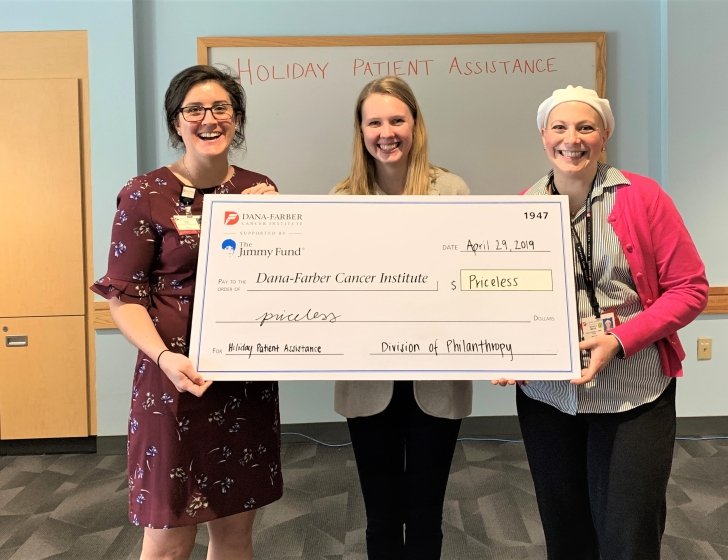 Casey, Hannah, and Michela holding a large check