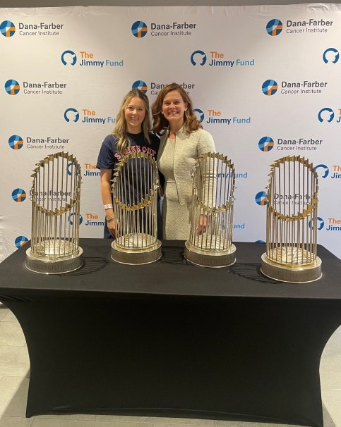 Meghan stands with Dr. Partridge behind table of World Series Champions trophies
