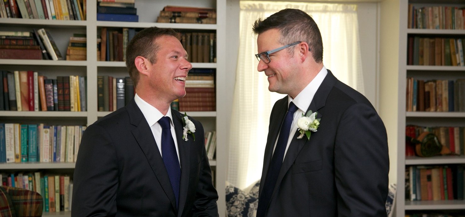 Justin and Mike smile together on their wedding day