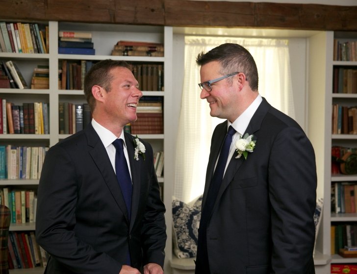 Justin and Mike smile together on their wedding day