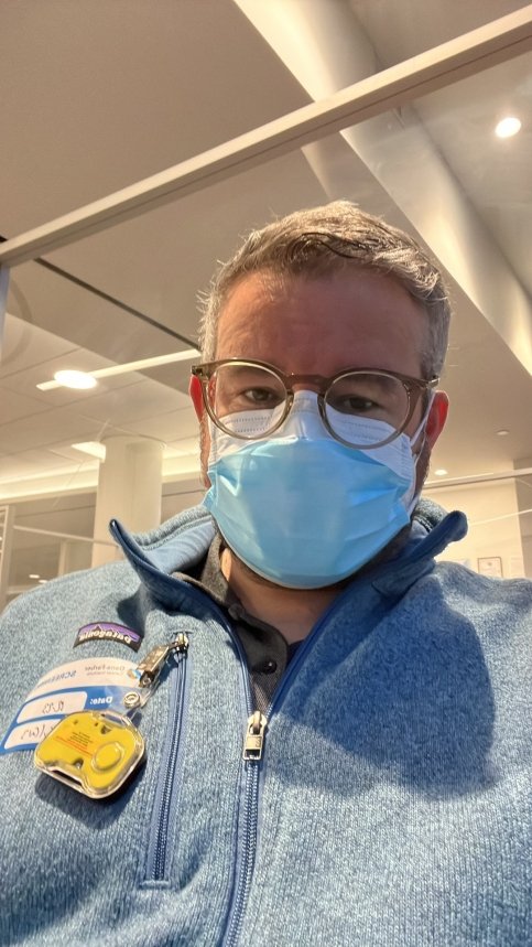 Justin wearing face mask and patient badge