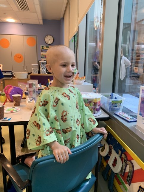 Patient sits on chair looking out of a window