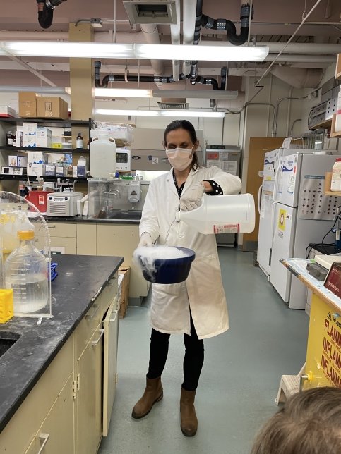 Dr. Nina pours steaming liquid into bowl in a lab