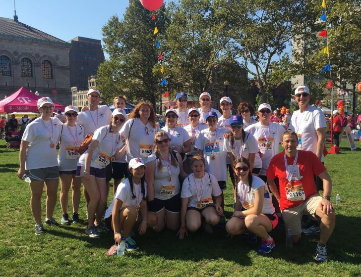 20-member Jimmy Fund Walk team stands together on lawn in Copley Plaza, Boston