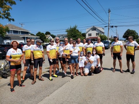 Group of bike riders stand together all wearing 'Team Stella' jerseys