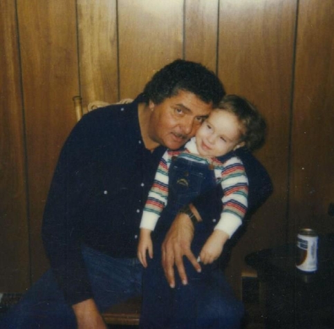 Adult and child sit together snuggling