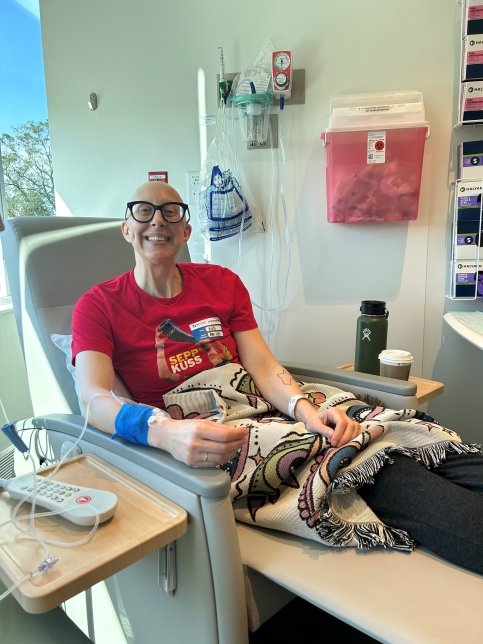 Gretchen sits in treatment chair with IVs