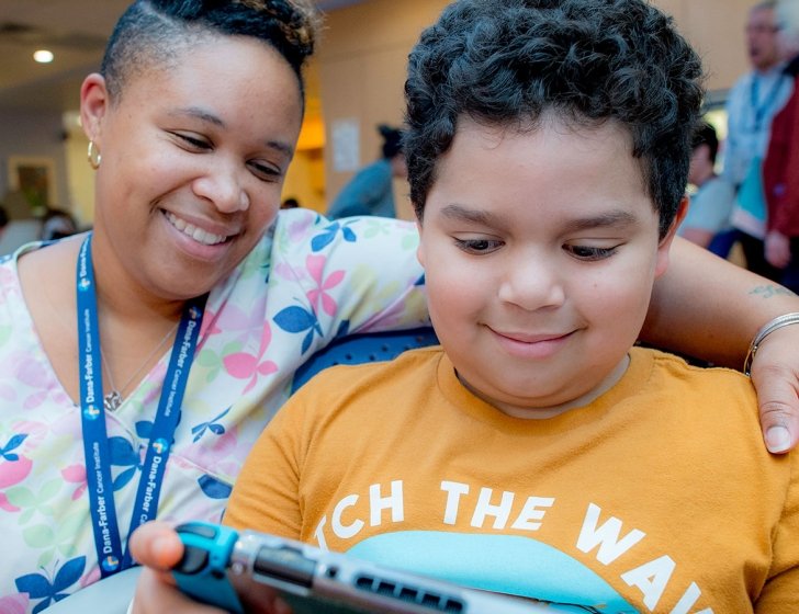 Child and staff member play a video game