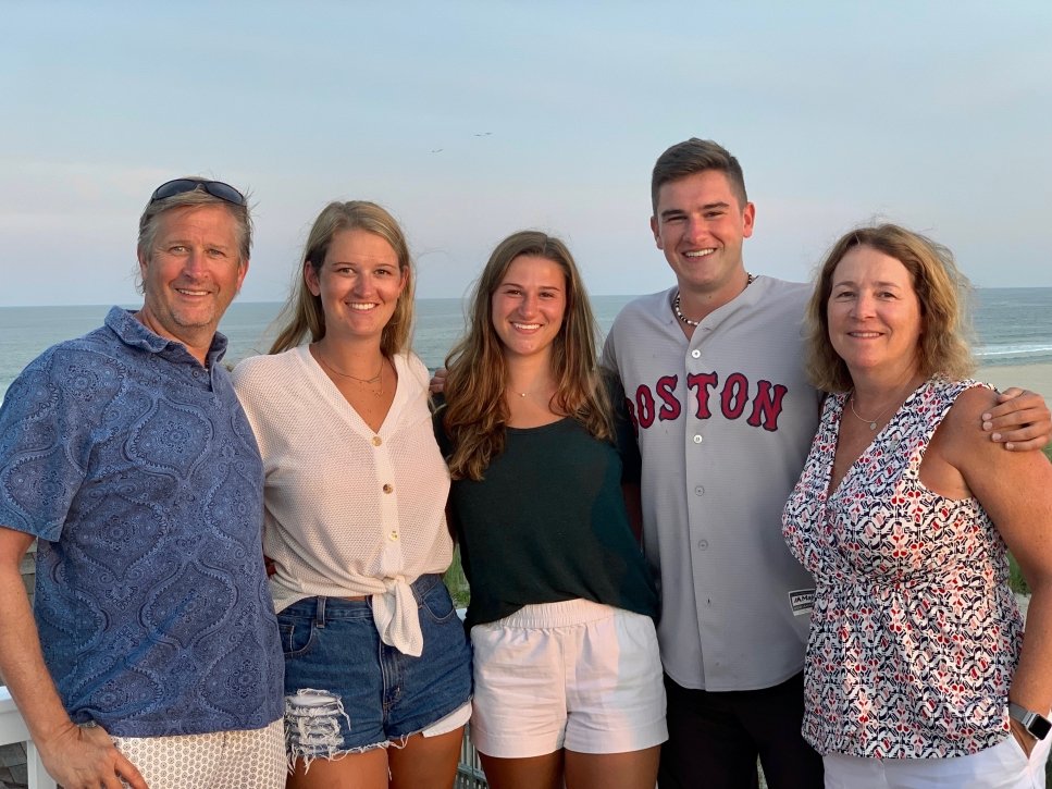 Grace stands with her family in front of the ocean