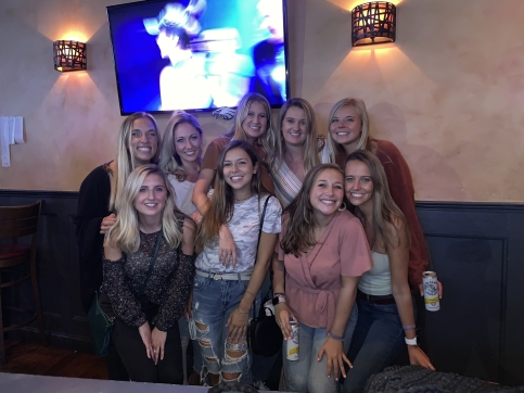 Grace and Gabby stand together with group of friends