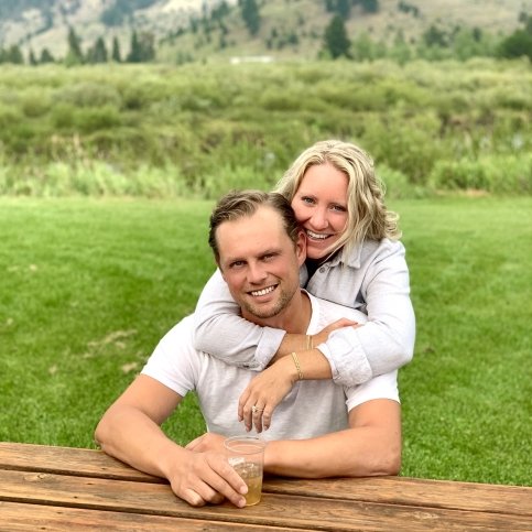 John and fiancée Sarah with field and mountains in background