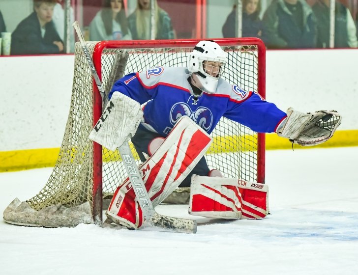 Ice hockey goalie catching a puck