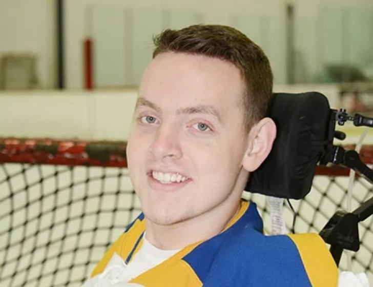 Matt in a hockey jersey at an ice rink