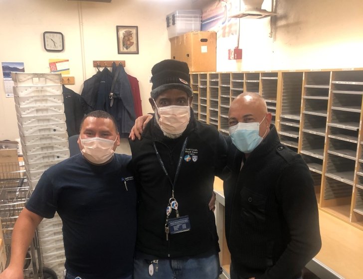 Three staff members in the Dana-Farber mailroom