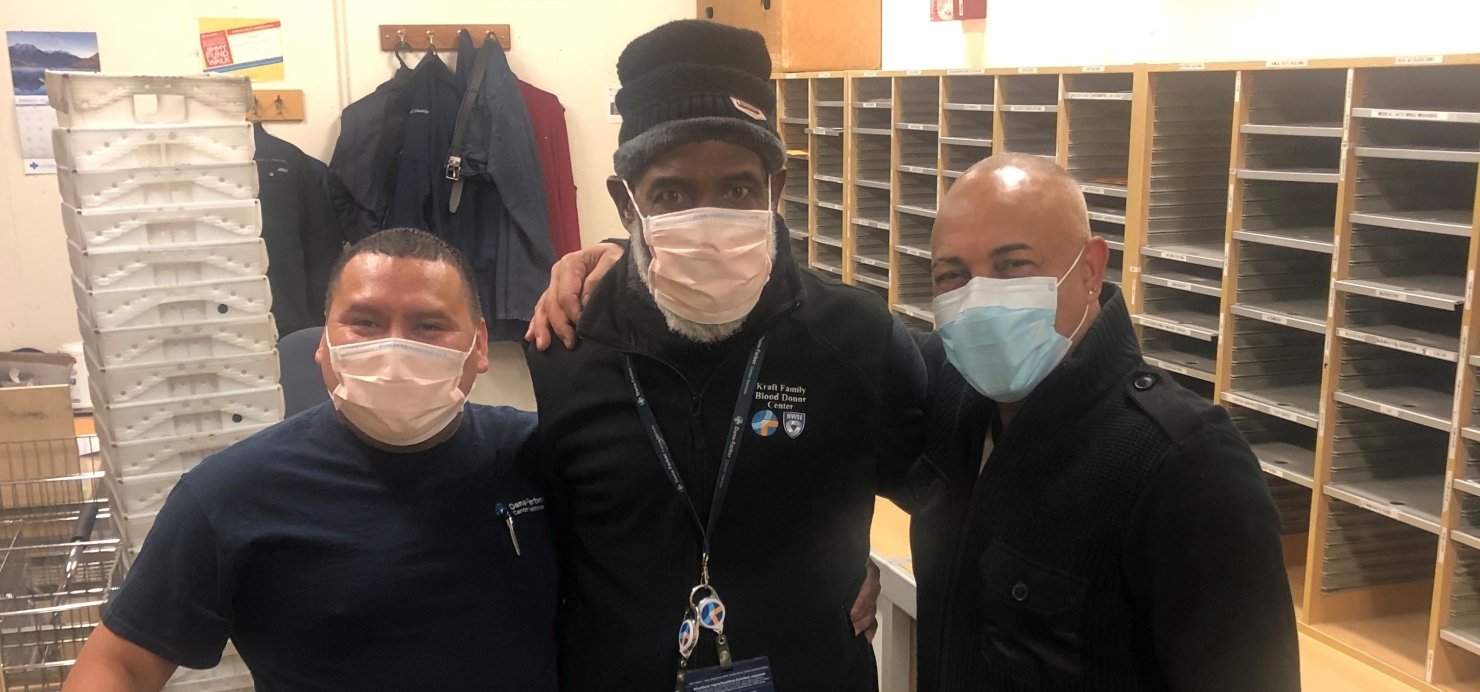 Three staff members in the Dana-Farber mailroom