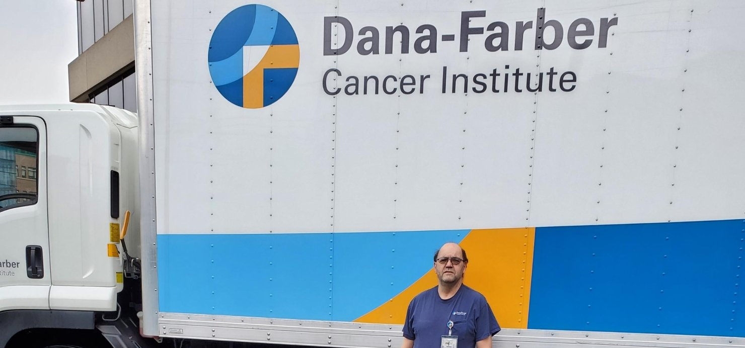 Michael standing in front of a large Dana-Farber branded truck