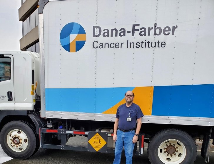 Michael standing in front of a large Dana-Farber branded truck