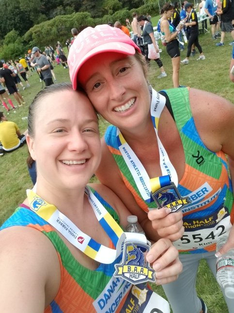 Sarah stands with teammate at the B.A.A. Half