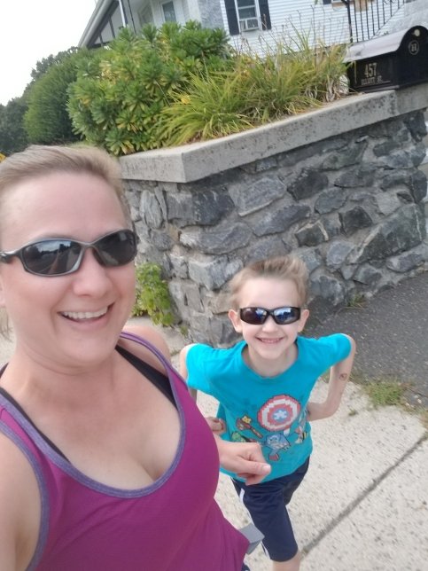 Sarah and Cian stand together on sidewalk, both wearing sunglasses