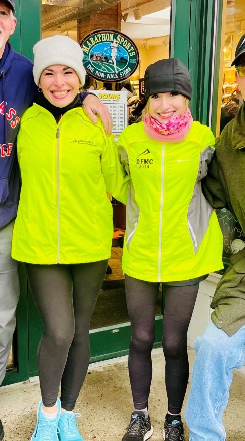 Ashley and Jamie stand together in front of a Marathon Sports storefront