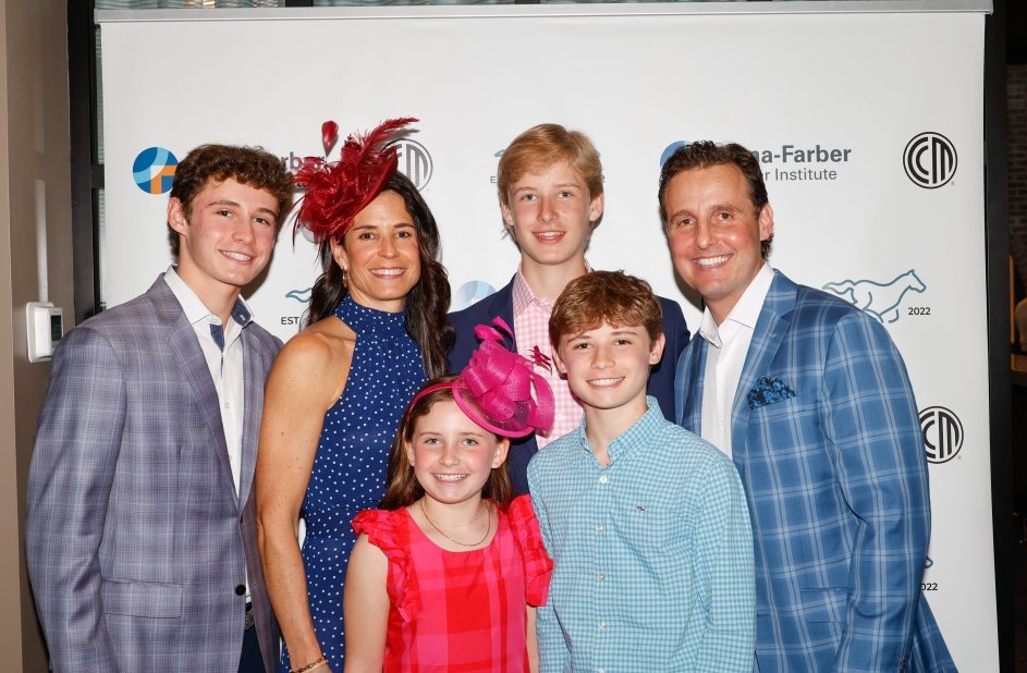 Patient and family stand together wearing suits and dresses