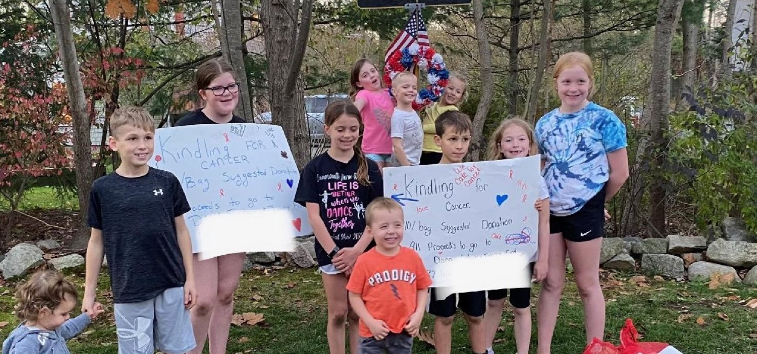 A group of children in a yard holding signs