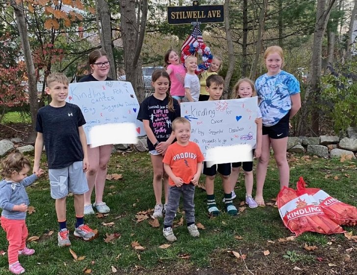 A group of children in a yard holding signs