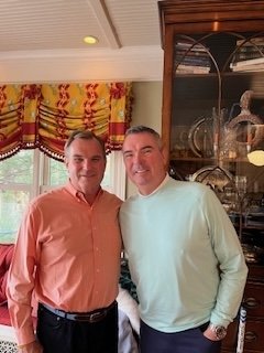 Bill and Matt stand together in living room