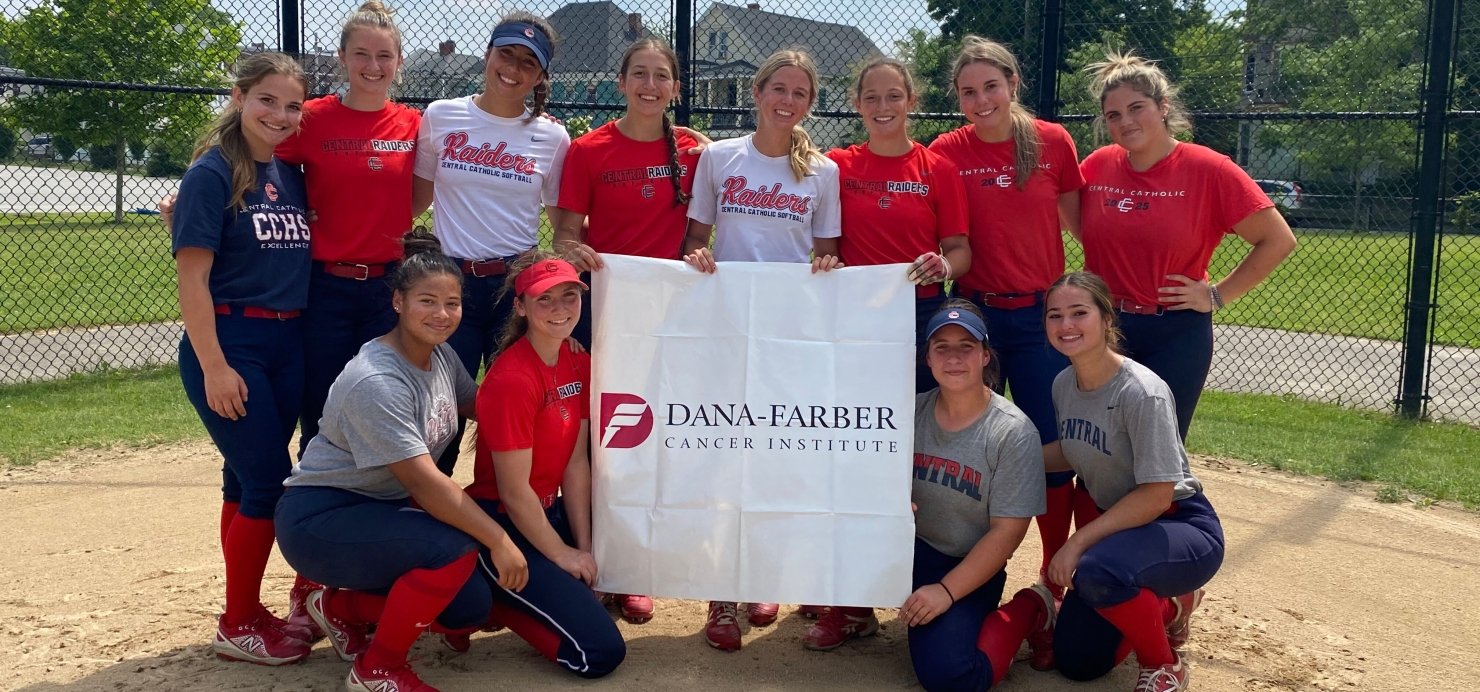 High school softball team on the field holding a Dana-Farber sign