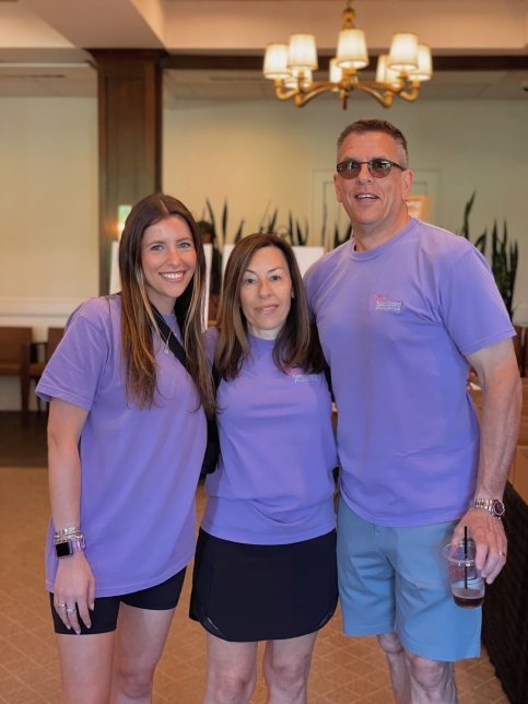 Haley stands with parents, all wearing purple T-shirts