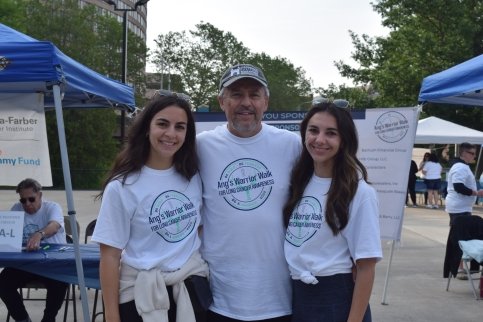 Two sisters and father next to event registration desk